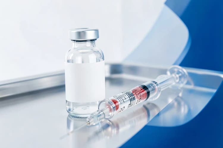 Frasco de testosterona e seringa sobre uma superfície limpa.